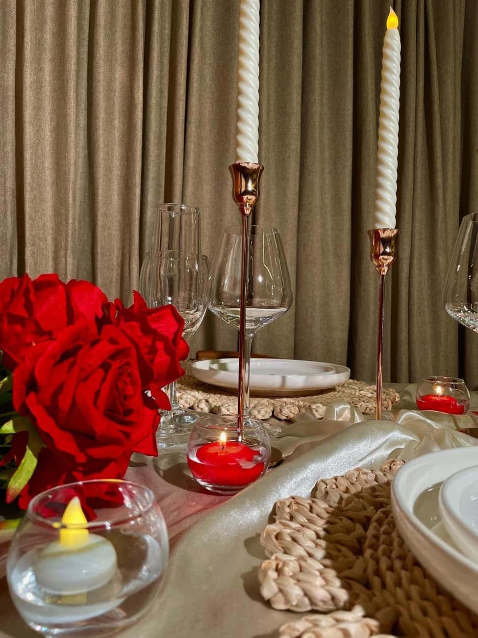 Red roses and gold candlesticks on table
