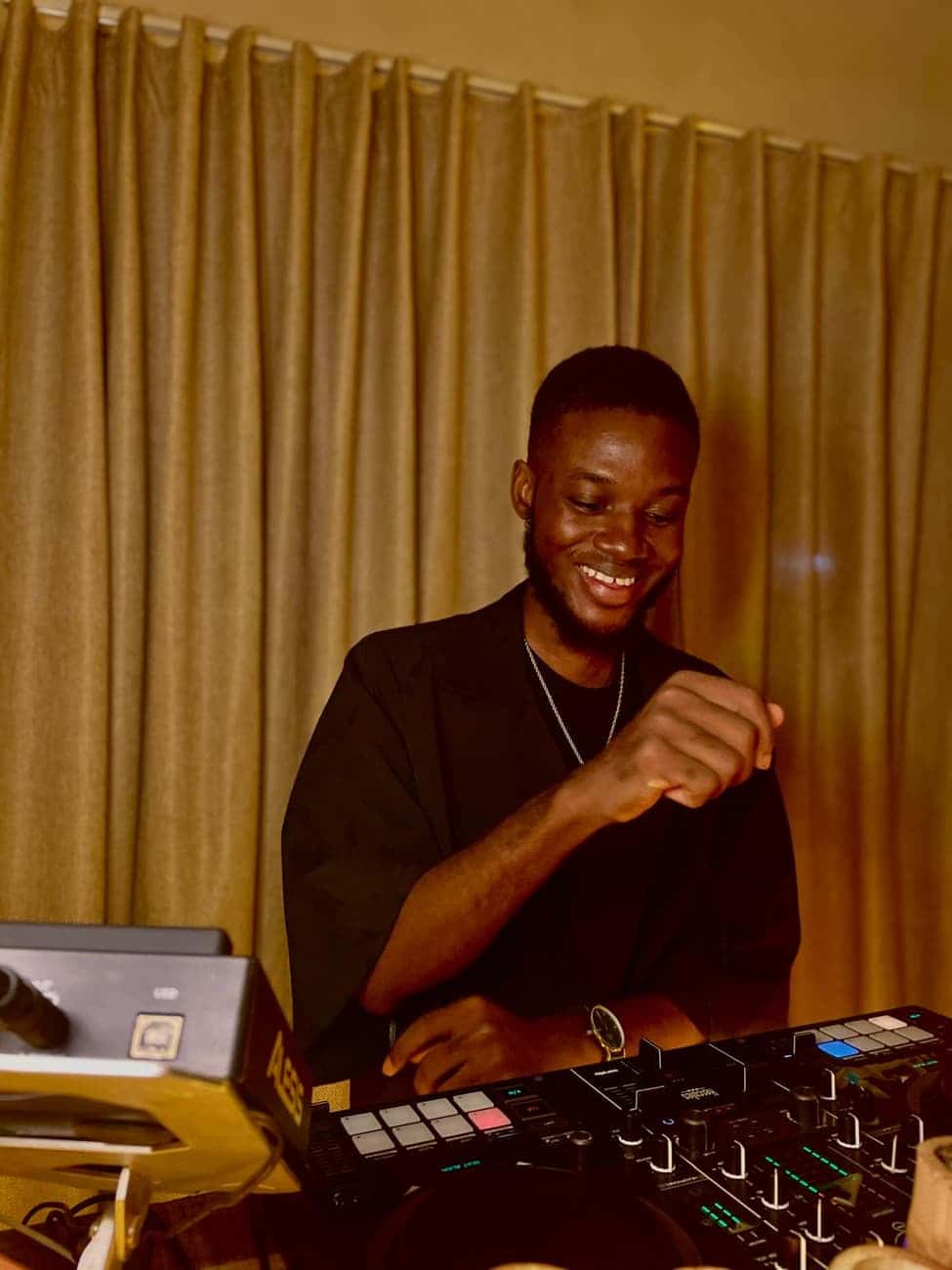 Smiling DJ mixing at evening event