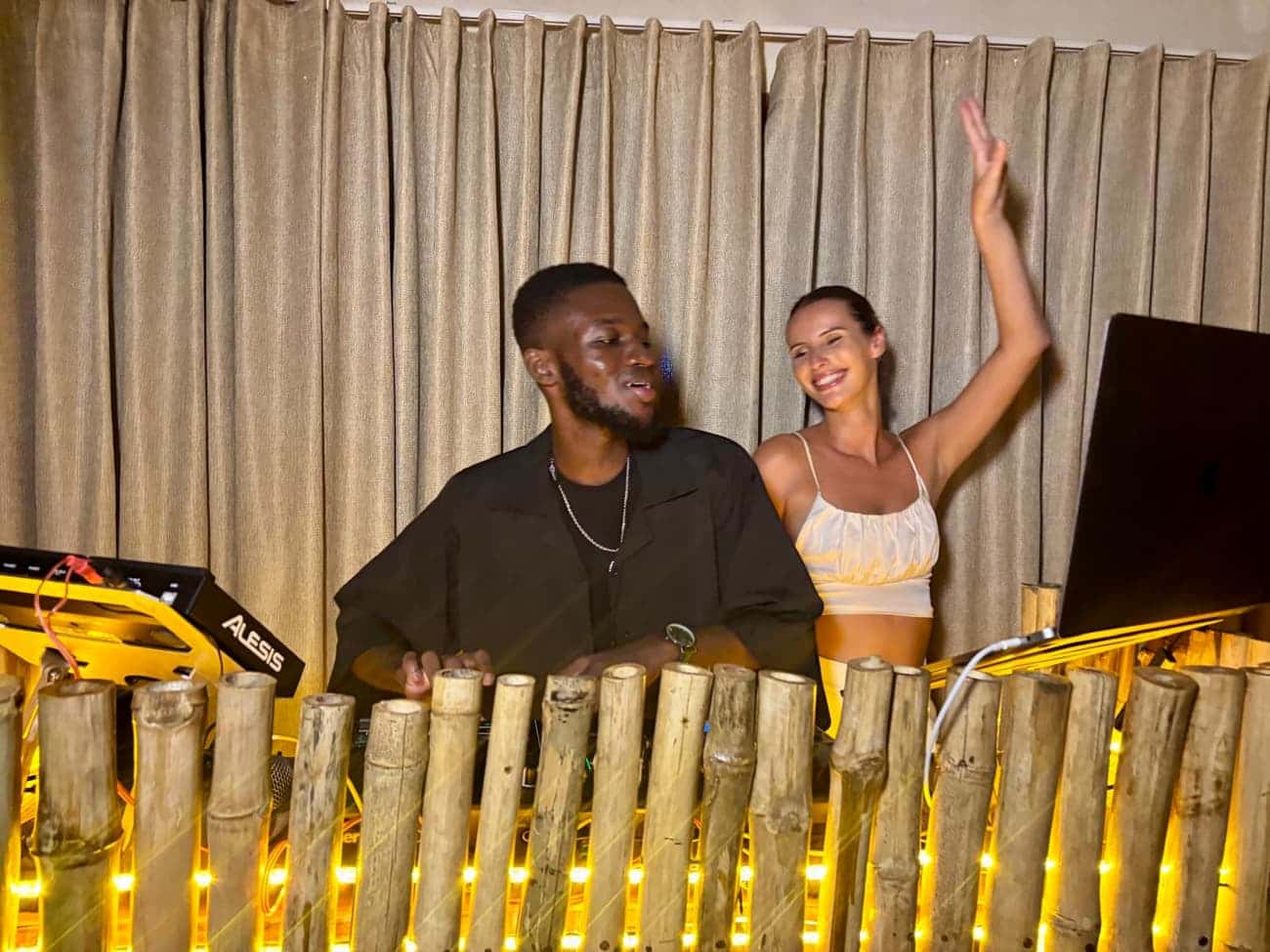 DJ performing, guest with raised arm