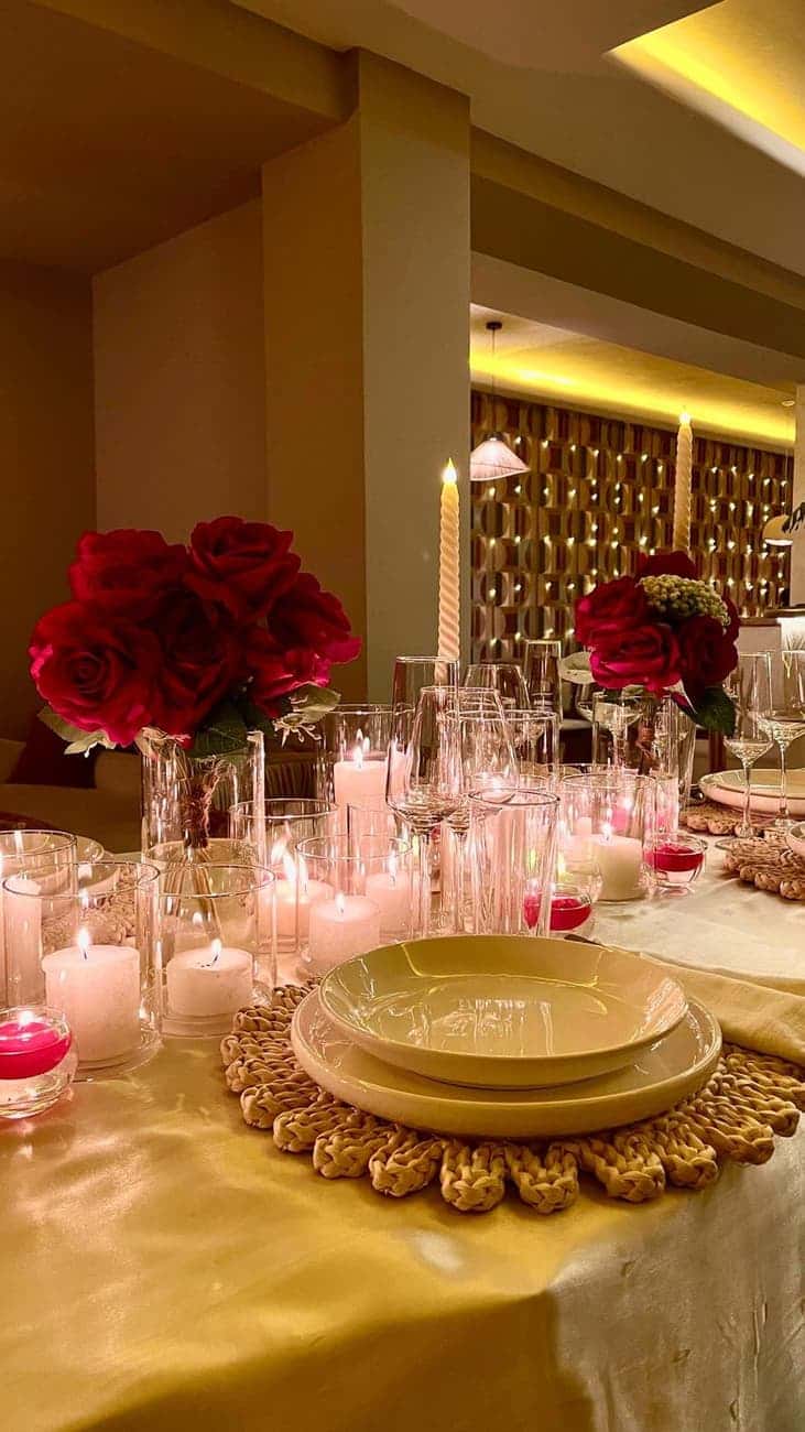 Set table with candles and red roses