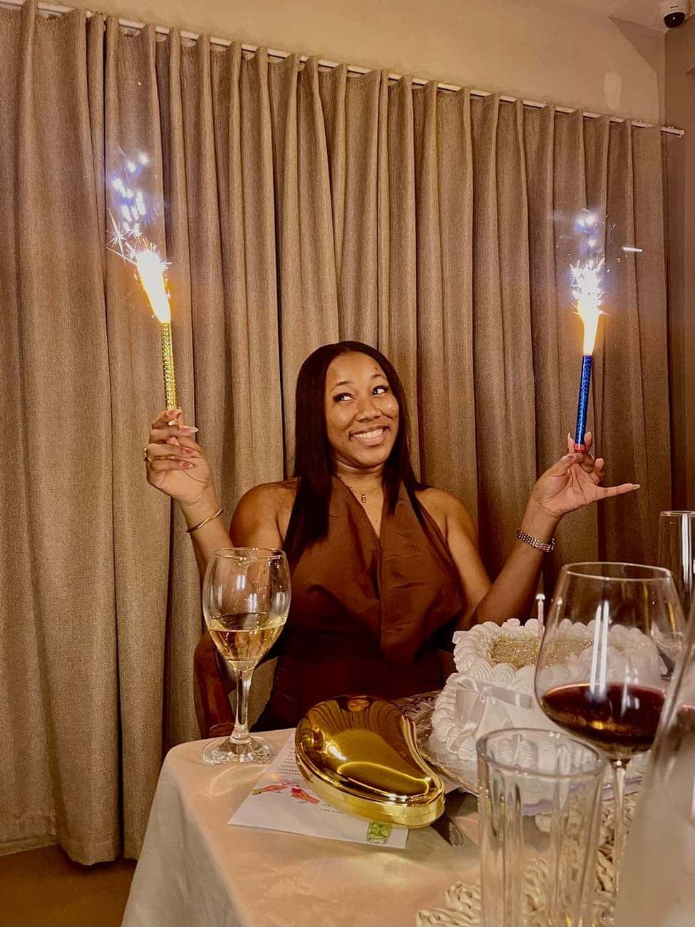 Smiling guest holding sparklers at table