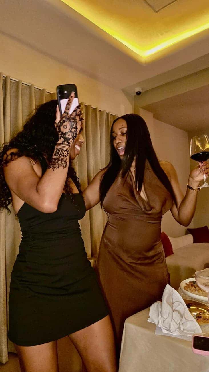 Two women dancing and toasting wine