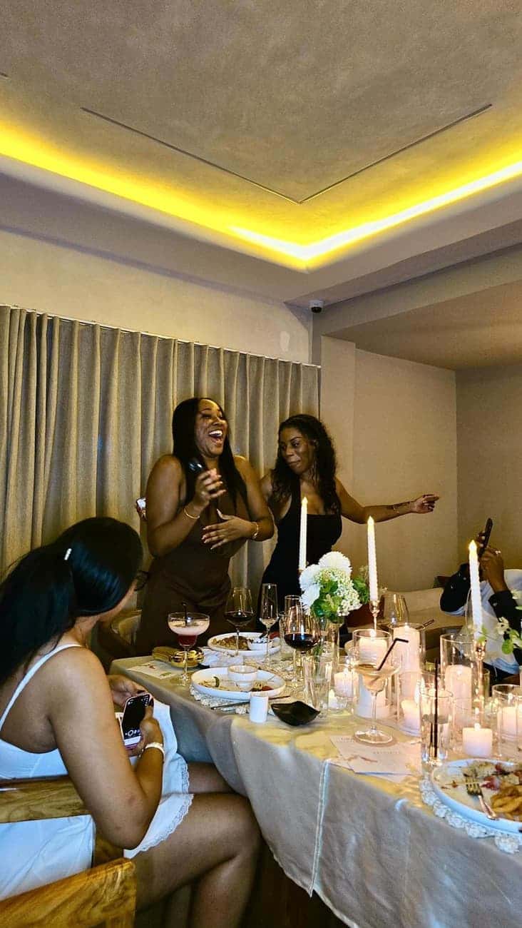 Guests laughing around a candlelit table